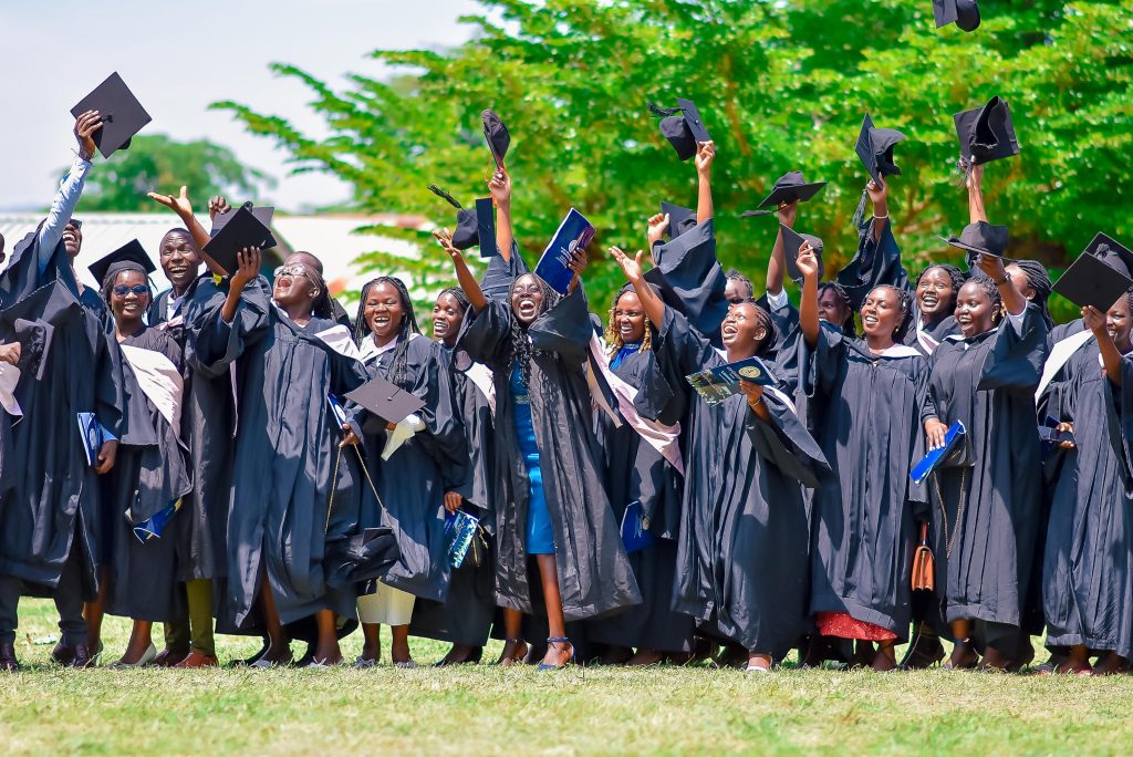 KASMS graduates in academic dress celebrating outdoors