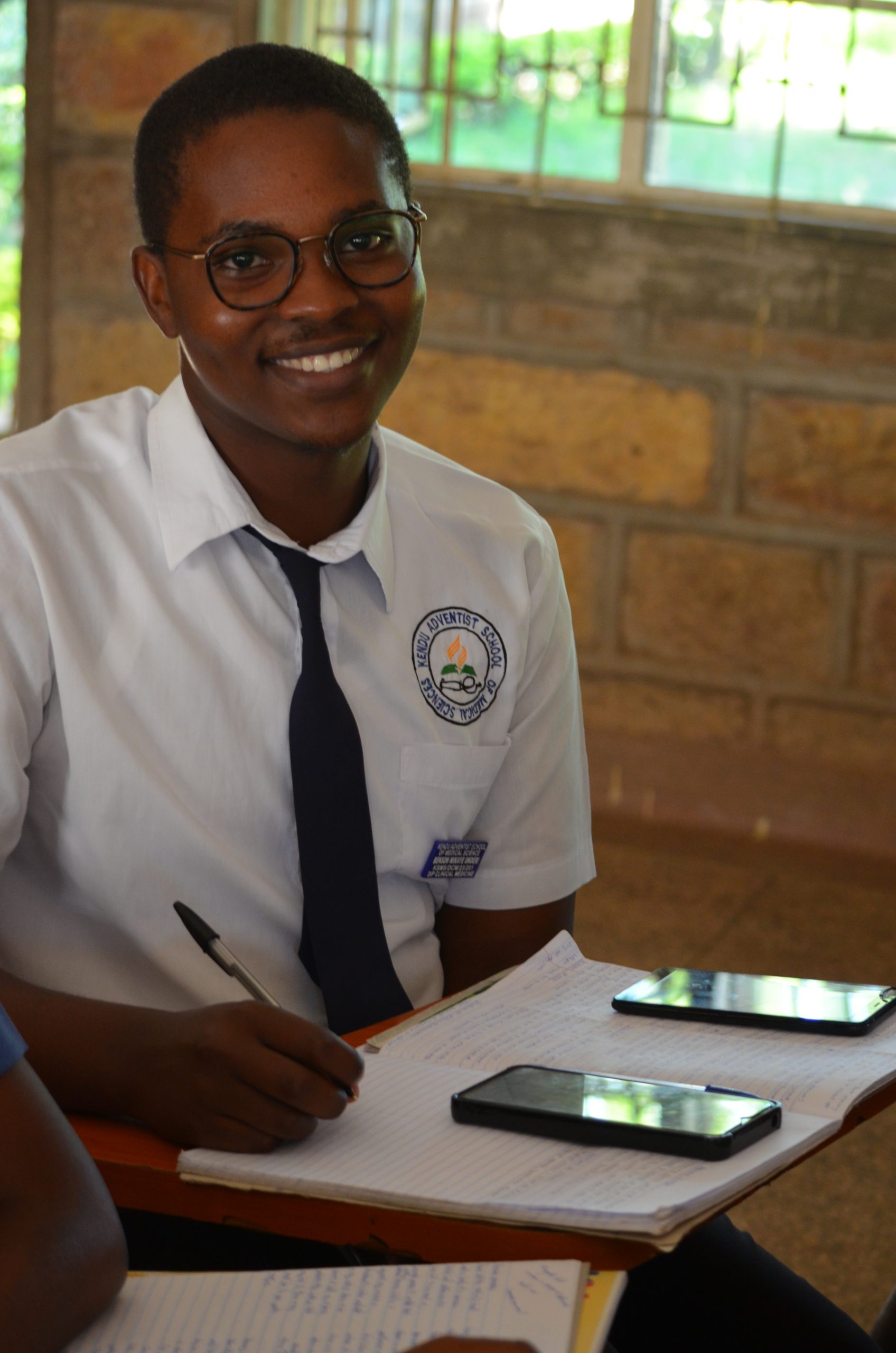 A KASMS student in uniform studying in class